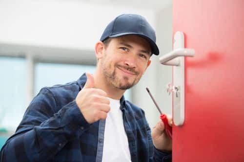 Professional locksmith holding screwdriver and giving thumbs up