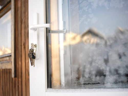 Open window of London home with keys in lock